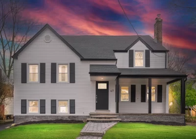 Stunning twilight real estate photo of an Australian property with glowing windows and sunset sky enhancement.