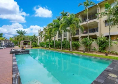 A residential swimming pool area with a professionally replaced, clear blue sky for a real estate listing.